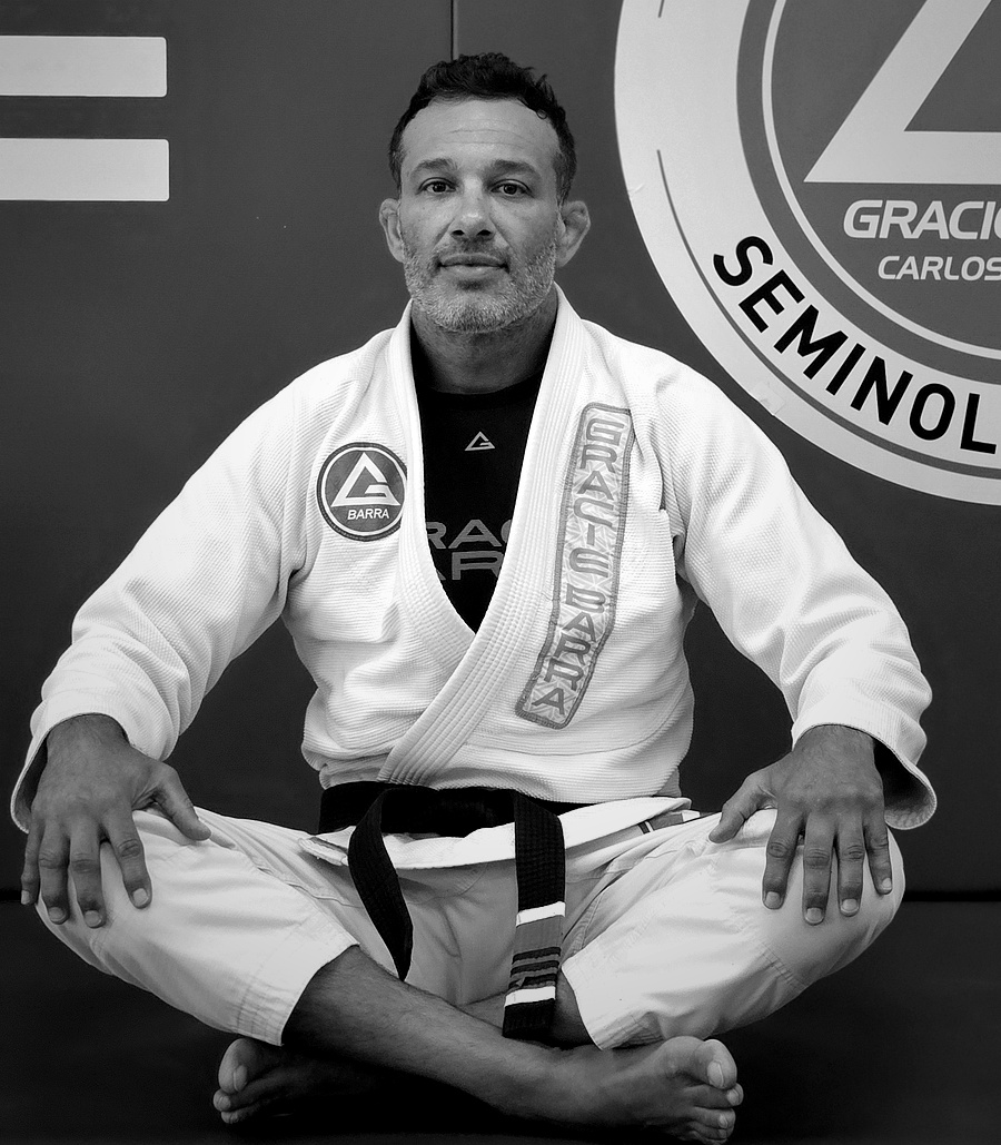 Professor Rodrigo Costa, Head Professor and Founder of Gracie Barra Seminole, seated full-figure in his 4th degree black belt gi